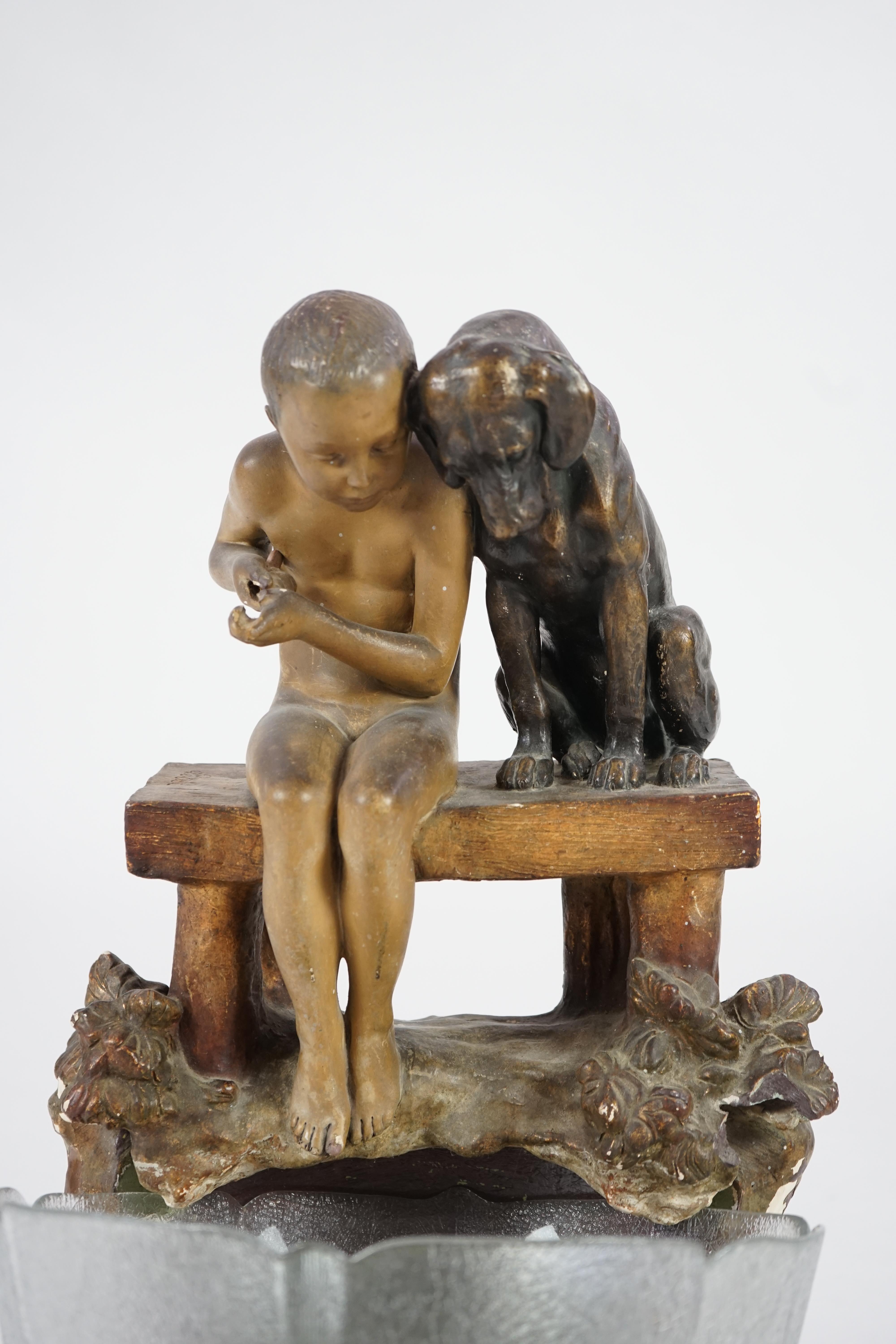 A Goldscheider group of a boy and a dog looking into a pool. Condition - fair, glass bowl not original